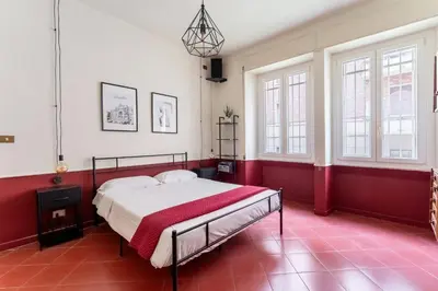 a red and white bedroom with a bed and windows at Maroon Flat Colosseo, 800 mt from Amphitheater in Rome