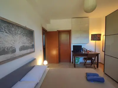 a bedroom with a bed and a desk with a computer at Parrot Room - Camera a Roma con bagno privato in Rome