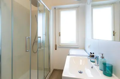 a bathroom with a sink and a glass shower at Pop Studio Trastevere in Rome