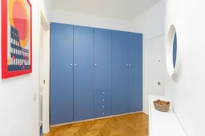 a blue closet in a white room with wood floors at Pop Studio Trastevere in Rome
