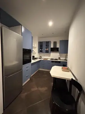 a kitchen with a refrigerator and a table in it at Roman Interlude in Rome
