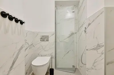 a white bathroom with a shower and a toilet at Casa di borgo in Rome