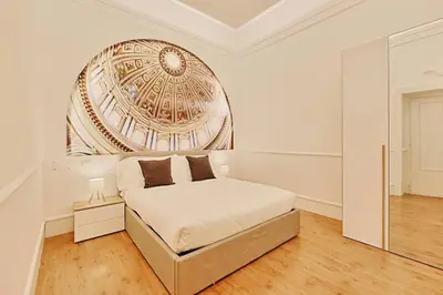 a white bedroom with a bed and a mirror at Casa di borgo in Rome