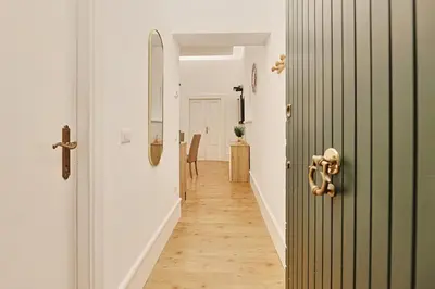 a hallway with a green door and a wooden floor at Casa di borgo in Rome