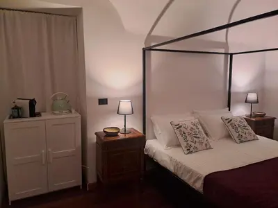 a bedroom with a canopy bed and a night stand at Romeo&Giulietta in Rome
