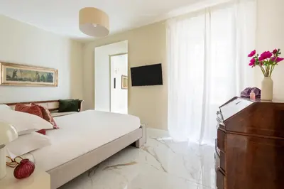 a white bedroom with a bed and a dresser at Casa Gold by Hili in Rome