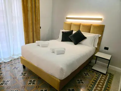 a large white bed with two pillows on it at Victoria Suites in Rome