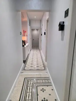 a hallway with a tile floor and a white hallway at Victoria Suites in Rome