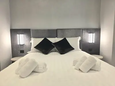 a large white bed with three pillows on it at Victoria Suites in Rome