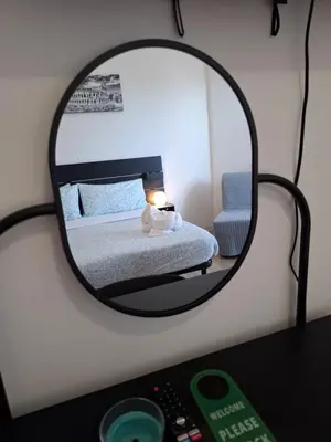 a mirror of a bedroom with a bed and a chair at Luma rooms in Rome