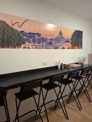 a table with chairs in a room with a picture on the wall at Luma rooms in Rome