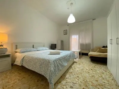 a white bedroom with a bed and a couch at Tiburtina2000 in Rome