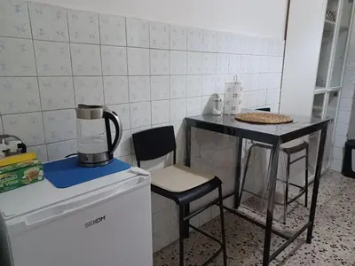 a small kitchen with a table and chairs next to a refrigerator at Tiburtina2000 in Rome