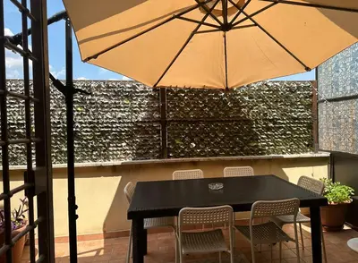 a black table and chairs with an umbrella on a patio at Lucian Dreams roma in Rome
