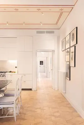 a kitchen with white cabinets and a table and chairs at Idyllia - Casa Mina in Rome