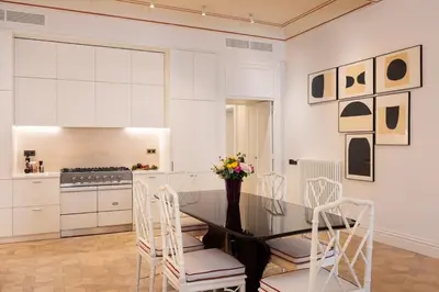 a white kitchen with a table and chairs at Idyllia - Casa Mina in Rome