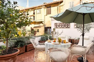 a patio with a table and chairs and an umbrella at Idyllia - Casa Mina in Rome