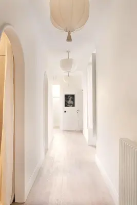 a hallway with white walls and a ceiling with a chandelier at Idyllia - Casa Mina in Rome
