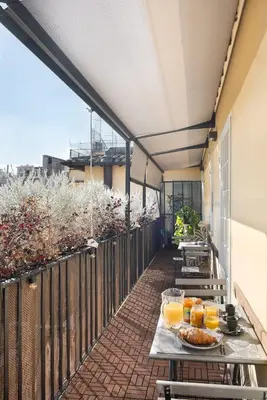 a balcony with a table with food and orange juice at Idyllia - Borgognona luxury home in Rome