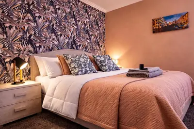 a bedroom with a bed and a wall at Mari & Lucio Bright Rome Apartment Sleeps 4 near Metro Basilica San Paolo- 4 Stops to Colosseum- Wi-Fi AC in Rome