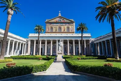 a building with palm trees in front of it at Mari & Lucio Bright Rome Apartment Sleeps 4 near Metro Basilica San Paolo- 4 Stops to Colosseum- Wi-Fi AC in Rome