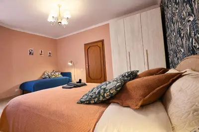 a bedroom with a bed and a blue couch at Mari & Lucio Bright Rome Apartment Sleeps 4 near Metro Basilica San Paolo- 4 Stops to Colosseum- Wi-Fi AC in Rome