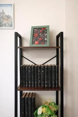 a book shelf filled with books next to a wall at Mari & Lucio Bright Rome Apartment Sleeps 4 near Metro Basilica San Paolo- 4 Stops to Colosseum- Wi-Fi AC in Rome
