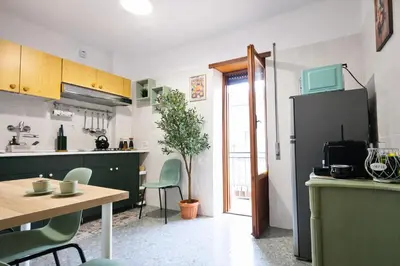a kitchen with a table and a refrigerator at Mari & Lucio Bright Rome Apartment Sleeps 4 near Metro Basilica San Paolo- 4 Stops to Colosseum- Wi-Fi AC in Rome