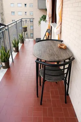 a table and chair sitting on a balcony at Mari & Lucio Bright Rome Apartment Sleeps 4 near Metro Basilica San Paolo- 4 Stops to Colosseum- Wi-Fi AC in Rome