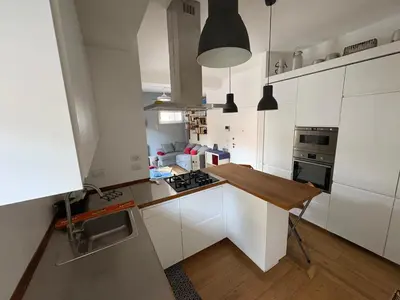 a kitchen with white cabinets and a wooden counter top at Urban Escape a Piazza Caprera in Rome