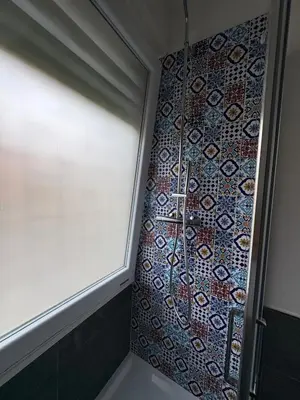 a shower with a window and a mosaic wall at Urban Escape a Piazza Caprera in Rome