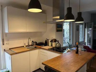 a kitchen with white cabinets and a wooden counter top at Urban Escape a Piazza Caprera in Rome