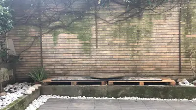 a stone wall with two benches in a garden at A CASA di BICE in Rome