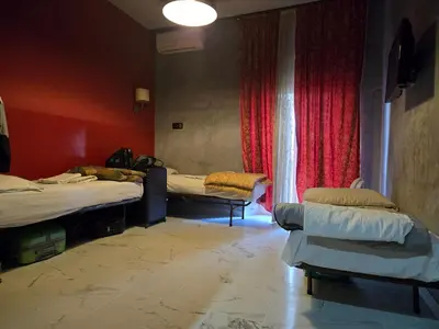 a room with two beds and a window at Arneil Rooms Rome in Rome