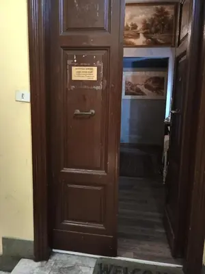 a wooden door in a hallway with a sign on it at Arneil Rooms Rome in Rome