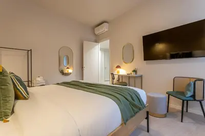 a bedroom with a large bed and a tv on the wall at BDC - Roman Lounge 3BDR at Vatican in Rome
