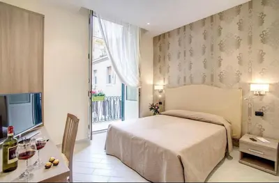 a hotel room with a bed and a table with wine glasses at Colosseo28 three private rooms in Rome