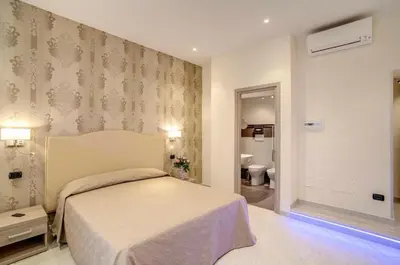 a bedroom with a bed and a bathroom at Colosseo28 three private rooms in Rome