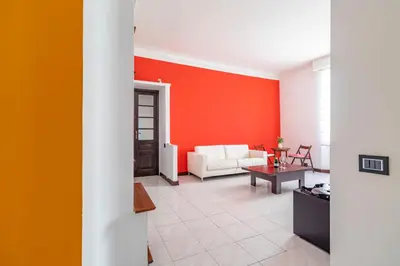 a living room with a white couch and a red wall at Vatican House in Rome