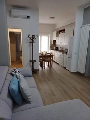 a living room with a gray couch and a kitchen at Ascenza in Trasteverere in Rome