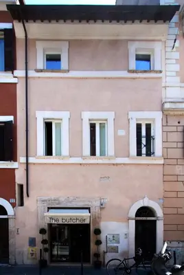 a large pink building with a store front at Apartment Ripa 17 in Rome