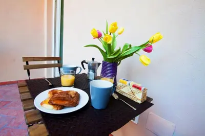 a table with a plate of breakfast food and flowers at Apartment Ripa 17 in Rome