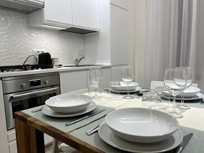 a kitchen with a table with plates and wine glasses at ARTPA Rome Apartments Trastevere Mameli, Roma in Rome