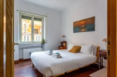 a bedroom with a white bed and a window at iFlat The Roman House - Spacious & Central Apt in Rome