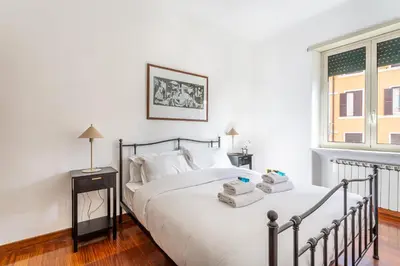 a bedroom with a bed with white sheets and a window at iFlat The Roman House - Spacious & Central Apt in Rome
