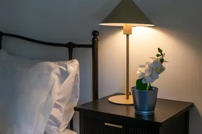 a table with a lamp and a potted plant on it at iFlat The Roman House - Spacious & Central Apt in Rome