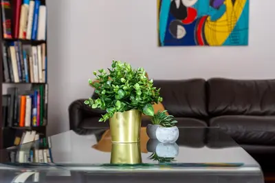 a gold vase with a plant on a coffee table at iFlat The Roman House - Spacious & Central Apt in Rome