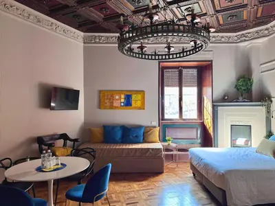 a living room with a bed and a chandelier at Z-ArchSuites URBE in Rome