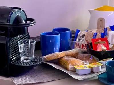 a table with bread and a coffee maker and cups at Z-ArchSuites URBE in Rome