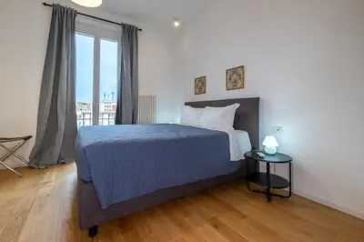 a bedroom with a bed and a large window at ht siesta sistina in Rome